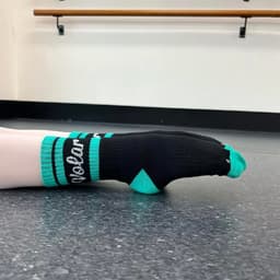 A pair of crew-length socks featuring black and teal colours, with a logo design on the black band.