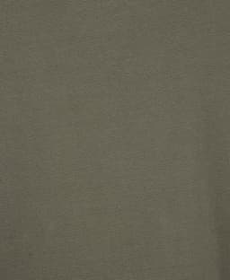 A close-up of a textured, olive-green polo shirt featuring a logo.