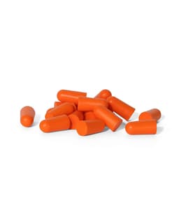 A collection of orange bullet-shaped earplugs scattered on a white surface.