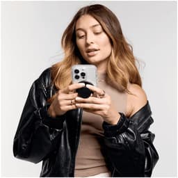 A person holding a smartphone with a PopSocket MagSafe attached, wearing a black leather jacket.