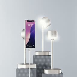 A smart lamp in silver with a minimalist design, featuring a phone charging on a pedestal.