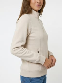 A woman wearing a grey half zip fleece jumper, featuring a fitted design and a logo on the front.