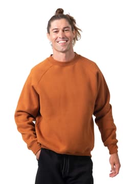 An adult wearing a rust-coloured cotton sweatshirt, featuring a relaxed fit and a simple design.