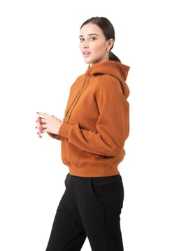 A model wearing a brown cotton hoodie with a kangaroo pocket and drawstring hood, alongside black pants.
