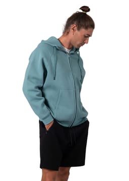 A men's cotton hoodie in teal with a kangaroo pocket and a zipper, worn with black shorts. The hoodie features a logo.