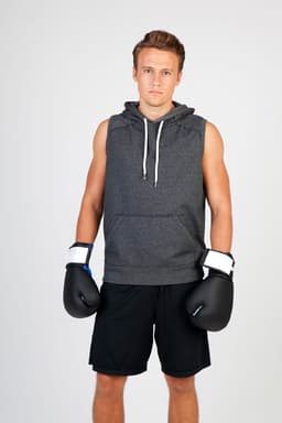Men's hooded sleeveless hoodie in dark grey, paired with boxing gloves and black shorts, modelled by a young man.