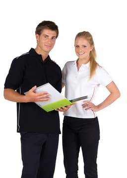 A man in a black polo shirt and a woman in a white polo shirt stand together, holding a folder. Both shirts feature contrasting piping.