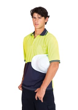 A high visibility polo shirt in bright yellow and navy, featuring a logo and held with a white hard hat.