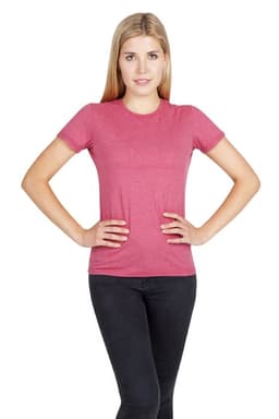 A woman stands with hands on hips, wearing a pink marl T-shirt and black jeans. The shirt has a logo.