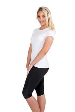 A woman poses in a fitted white slim fit tee paired with black leggings, showcasing a clean and casual look.