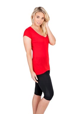 A woman wearing a red V-neck T-shirt paired with black capri leggings, standing against a white background.