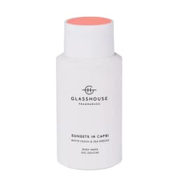 A white body wash bottle with a pink lid, featuring a logo and the name "Sunsets in Capri."