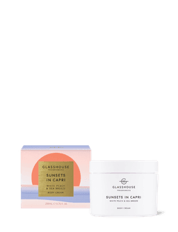 A white jar of body cream with a pastel box, featuring the scent White Peach & Sea Breeze.