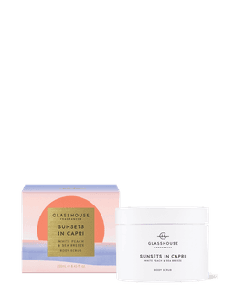 A white body scrub jar with a pink and gold box, featuring the scent of white peach and sea breeze.