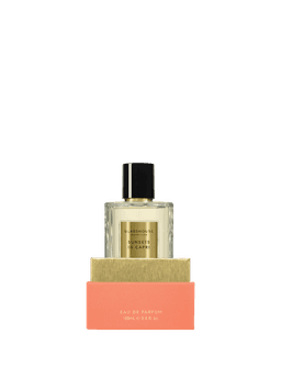 A glass bottle of Eau de Parfum filled with a clear liquid, presented in a peach and gold boxed packaging.