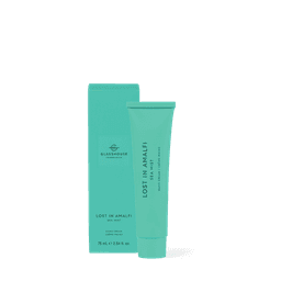 A turquoise hand cream tube in a matching box, labelled "Lost In Amalfi," with a logo on the packaging.