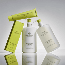 A hand cream and lotion duo in sleek white bottles, featuring a vibrant green box, labelled with "Montego Bay Rhythm."