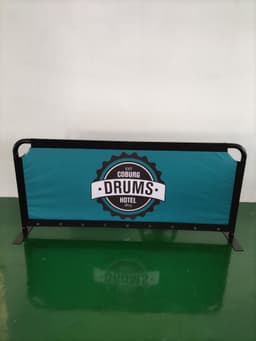 A teal crowd barrier replacement skin featuring a round logo in black and white. The structure is black with a solid base.