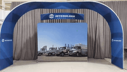 A large arch display with a blue and white design, featuring an image of trucks on a fabric background.