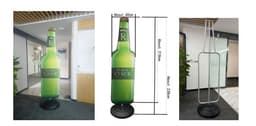 A drink bottle shaped display in green with a water base, measuring 600mm x 2000mm. Features a logo.