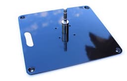 A flat metal base in black with a central cylindrical attachment and four corner holes for mounting.
