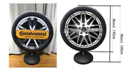 A round promotional display featuring a tyre design, with a black base and branded artwork on the front.