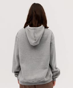 A grey hoodie with a large hood, featuring dropped shoulders and a relaxed fit. It has a logo on the back.