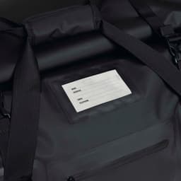 A black duffle bag with adjustable straps and a clear identification panel. The bag has a pocket with a zipper.