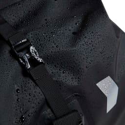 A black waterproof duffle bag with a buckle closure, featuring a textured surface and droplets of water.
