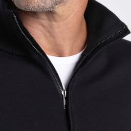 A close-up of a black Merino zip-up shirt for men, featuring a high collar and a visible zipper.