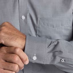 A men's button-up shirt featuring a small check pattern in grey, with a front pocket and buttoned cuffs.