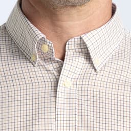 A button-up shirt featuring a check pattern in beige and navy, with a button-down collar. It has a logo on the chest.