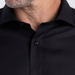 A black button-up shirt with a textured fabric and collar, featuring a logo on the design.