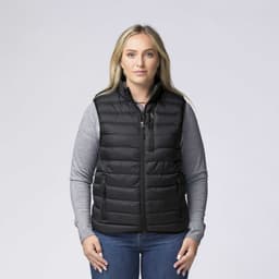 A black padded baffle vest features zippered pockets and is worn over a grey long-sleeve shirt.