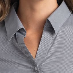 A button-up women's shirt in a checkered black and white pattern, featuring a pointed collar and button details.