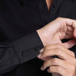 A black button-up shirt featuring a close-up of the cuff and buttons.