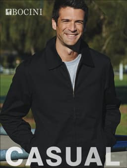 A man wearing a black unisex adults canvas jacket stands outdoors, smiling. The jacket features a brand logo.