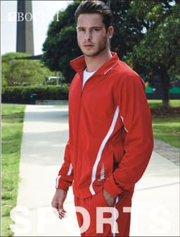 A red track jacket featuring white stripes, modelled by a male model in an outdoor setting. The jacket has a logo.