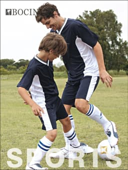 A pair of unisex adults soccer panel shorts in navy blue and white, featuring a logo, worn by two players on a grassy field.
