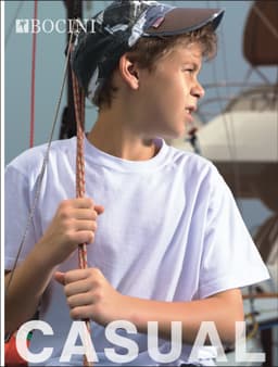 A plain white cotton t-shirt worn by a boy, with a camouflage cap, against a nautical background.