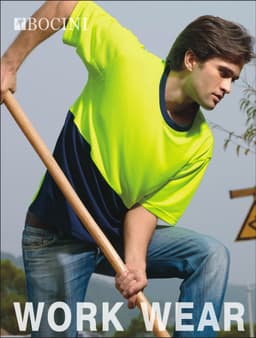 A man wearing a bright yellow and navy hi-vis safety tee, engaged in outdoor work with a shovel. The shirt has a logo.