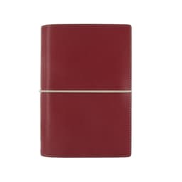 A red organiser with a smooth finish, secured with a rubber band, featuring stitching detail.