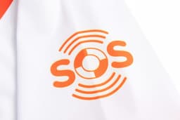 A white sports uniform featuring an orange logo with concentric circles and the letters "SOS".