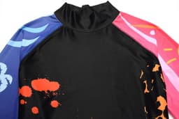 A rash guard featuring a black body and multicoloured sleeves with vibrant patterns and a high neck design.