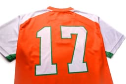 An orange and white sports jersey featuring a large green number 17 on the back.