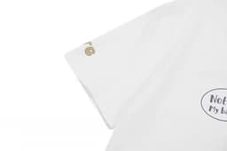 A white cotton t-shirt featuring a logo and printed designs on the front and sleeve.