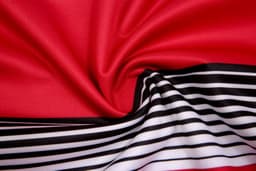 A red fabric with a smooth texture, featuring black and white stripes along one edge.