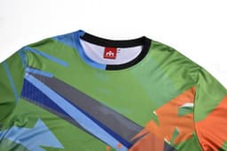 A long sleeve T-shirt featuring a vibrant green, blue, and orange abstract design. It has a logo tag.