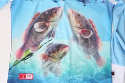 A colourful fishing-themed hoodie features three fish surrounded by bubbles, with a fishing lure in the water. The hoodie has a logo.