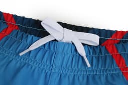 A pair of rugby shorts featuring a blue body with red accents and a grey drawstring at the waistband.
